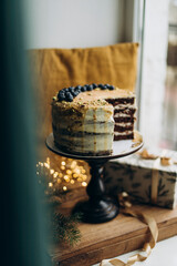 peek at the cake that lies on the cake stand. cake with white cream and caramel with berries on top. birthday cake
