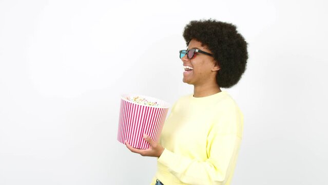 Young African American woman holding a bowl of popcorns over isolated background