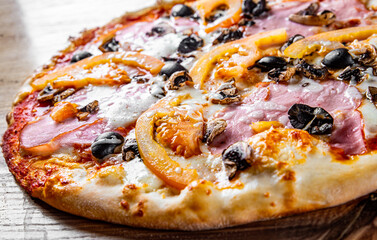 pizza with Mozzarella cheese, ham, mushrooms, olive. Italian pizza on wooden table background