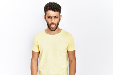 Arab young man standing over isolated background sticking tongue out happy with funny expression. emotion concept.