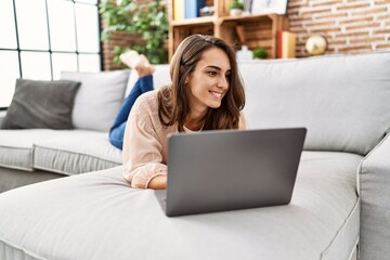 Fototapeta na wymiar Young hispanic woman smiling confident using laptop at home