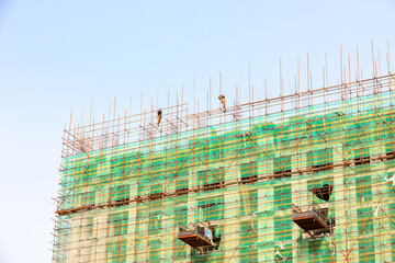 construction workers build scaffolding at a construction site in North China