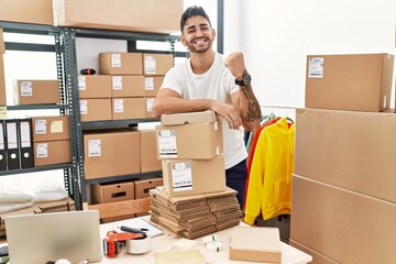 Young hispanic man working at small business ecommerce screaming proud, celebrating victory and...
