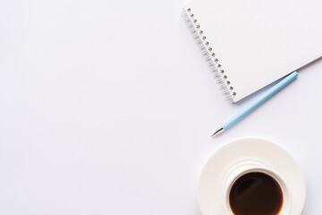 Flat lay, top view office table desk. Workspace with notebook, office supplies, pen and coffee cup with copy space on white background.