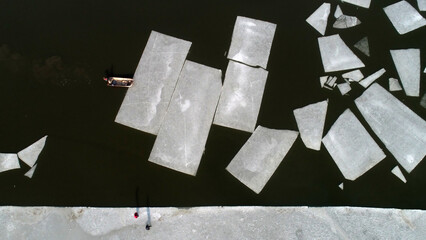 Farmers use boats to move ice on the water, North China