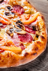 pizza with Mozzarella cheese, ham, mushrooms, salami. Italian pizza on wooden table background