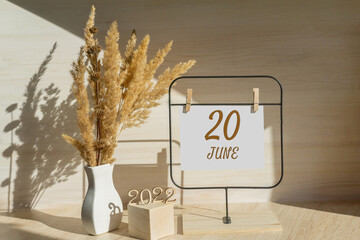 june 20. 20th day of month, calendar date. White vase with dead wood next to the numbers 2022 and stand with an empty sheet of paper on table. Concept of day of year, time planner, summer month