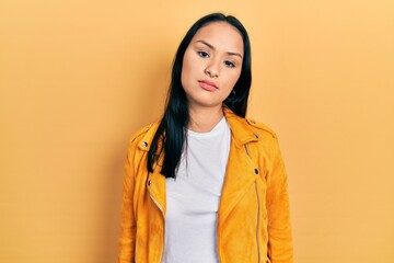 Beautiful hispanic woman with nose piercing wearing yellow leather jacket looking sleepy and tired,...