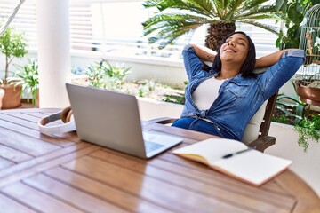 Hispanic brunette woman resting after studying with laptop at the terrace