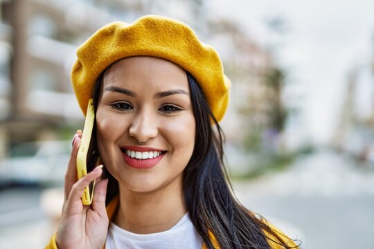 Young latin girl smiling happy talking on the smartphone at the city.