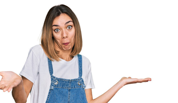 Young blonde girl wearing casual clothes clueless and confused expression with arms and hands raised. doubt concept.
