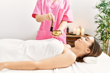 Obraz na płótnie Canvas Young hispanic woman having oil treatment at beauty center.