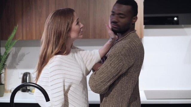 Young couple quarrel. Angry wife screams at her husband and insults him.