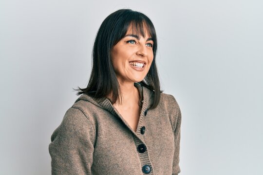 Young hispanic woman wearing casual clothes looking to side, relax profile pose with natural face and confident smile.
