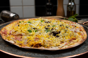 Brazilian Portuguese-style pizza with ham, egg, pepper, onion, mozzarella