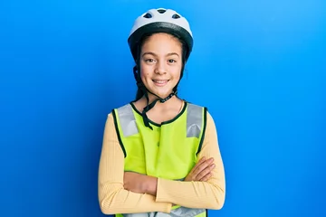 Foto op Canvas Beautiful brunette little girl wearing bike helmet and reflective vest happy face smiling with crossed arms looking at the camera. positive person. © Krakenimages.com