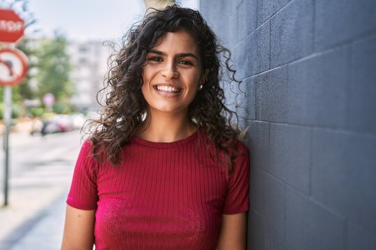Young latin woman smiling confident standing at street