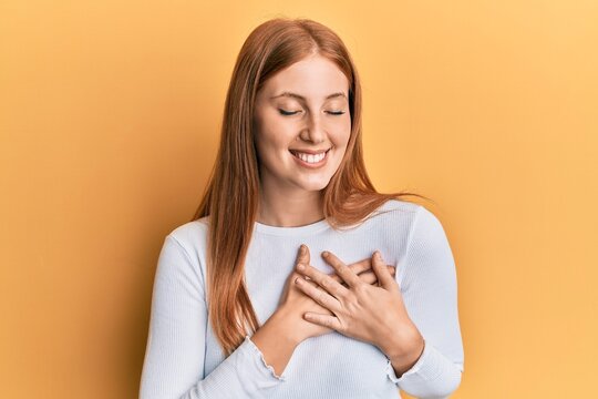 Young irish woman wearing casual clothes smiling with hands on chest, eyes closed with grateful gesture on face. health concept.