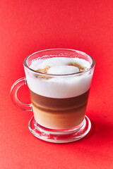  One cup of cappuccino coffee over red background