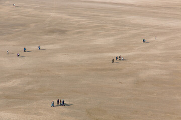 A stretch of beach with people walking in the Netherlands