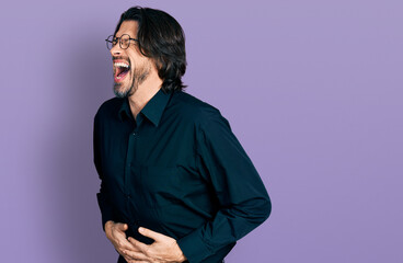 Middle age caucasian man wearing casual clothes and glasses with hand on stomach because nausea, painful disease feeling unwell. ache concept.