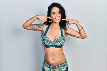 Fototapeta premium Young woman wearing bindi and traditional belly dance clothes smiling cheerful showing and pointing with fingers teeth and mouth. dental health concept.