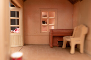 Obraz na płótnie Canvas ドールハウスを窓から覗く子供
