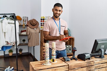 Young arab man using touchpad working at clothing store