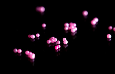 Pink plastic balls on a black background.