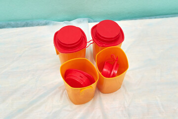 Medical red container for the collection of tests with an open lid on the background of other containers. Concept: passing medical tests.