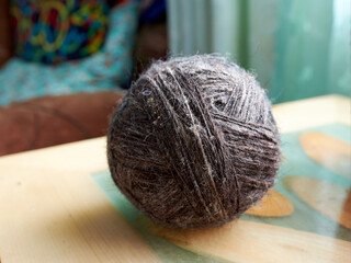 A ball of yarn, wool, bright sunlight on a beige background. The concept of knitting, needlework, hobby.