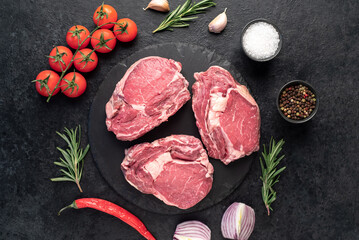 raw beef steaks on stone background