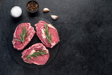 raw beef steaks on stone background with copy space for your text	