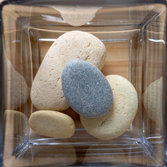 still life with stones (inside a glass jar sitting on a wooden surface)