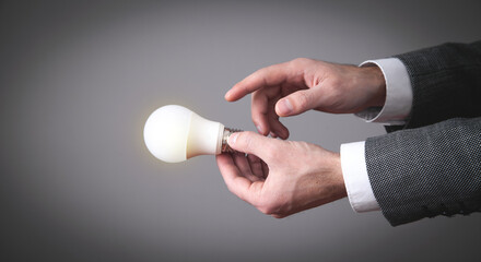 Male hand holding light bulb.