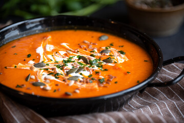 Pumpkin soup with cream and parsley in bowl