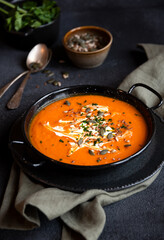 Pumpkin soup with cream and parsley in bowl