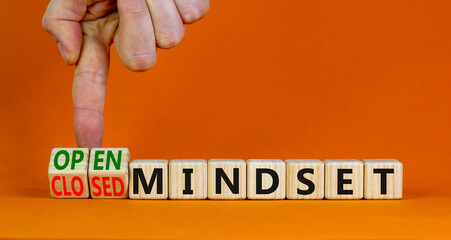 Open or closed mindset symbol. Businessman turns wooden cubes and changes concept words closed mindset to open mindset. Beautiful orange background copy space. Business open or closed mindset concept.