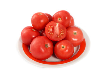 A handful of whole ripe tomatoes on a plate. Isolated on a white background. Ripe vegetables.