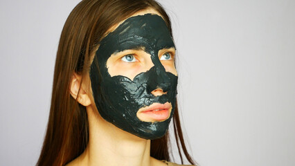 Close-up of a beautiful girl’s face with a mud therapeutic mask