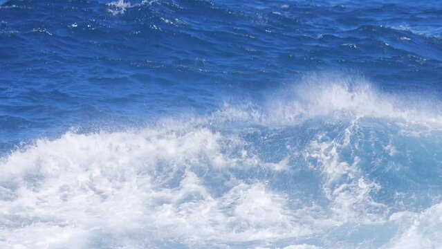 Powerful and fierce ocean waves breaking onto shore sending foamy mist into the air. Static medium shot