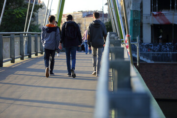 Mężczyźni idą przez most we Wrocławiu. - obrazy, fototapety, plakaty