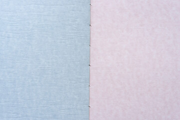 Fototapeta premium textured paper background in blue and pink with focus on binding
