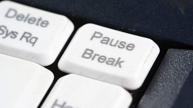 Man taking a break, pause, rest abstract lifestyle concept, finger pressing the pause break key on a computer keyboard, macro, detail, extreme closeup. Pushing break button, pausing activity metaphor