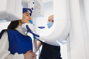 Female patient make a dental computer tomograph. The radiologist makes a CT scan of the jaw