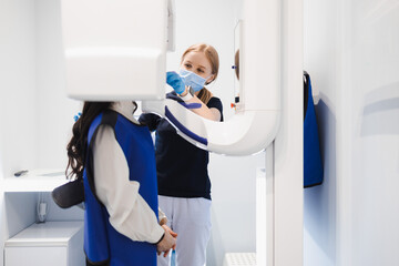 Female patient make a dental computer tomograph. The radiologist makes a CT scan of the jaw. Woman...