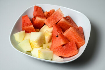 Sliced Cantaloupe melon and Watermelon mixed in the same soup plate