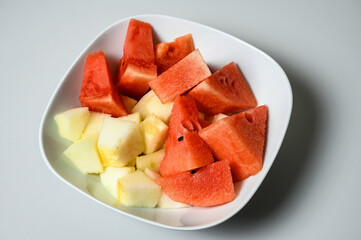 Sliced Cantaloupe melon and Watermelon mixed in the same soup plate