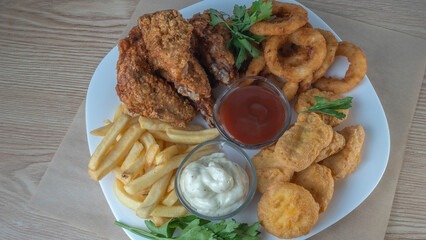 Snack platter - cheese sticks, chicken nugget, onion rings, french fries mix of snacks and sauces . Beer board.