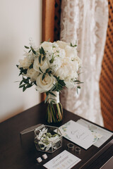 style, floral arranging, wedding concept. young woman dressed in extremely beautiful snowy white dress with puffy skirt is holding great bunch of different flowers stretched with yellow ribbons.